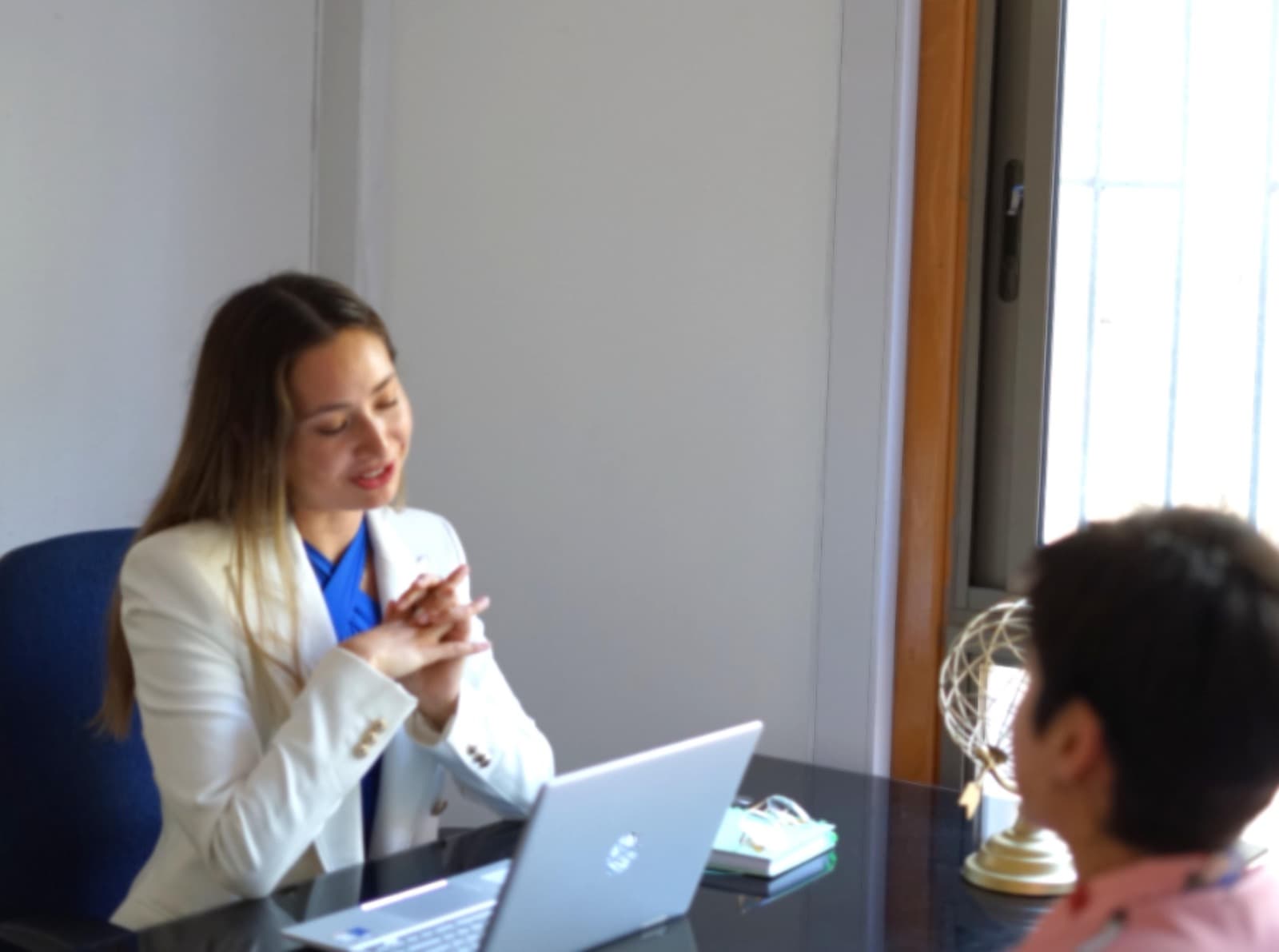 Valeria Pacheco atendiendo a un cliente en su oficina